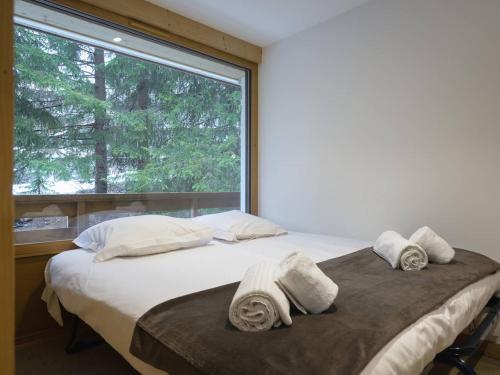 谷雪维尔Appartement Courchevel, 2 pièces, 4 personnes - FR-1-631-133的一间卧室设有一张床和一个大窗户