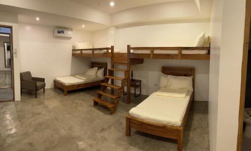 黎牙实比P&B Residences Legazpi的客房设有两张双层床和一张书桌。