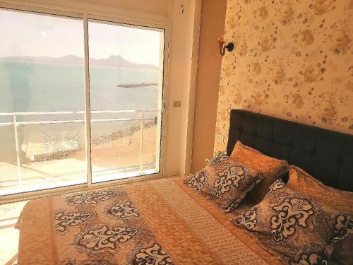 拉古莱特La perle bleue的一间卧室配有一张床,享有海滩美景