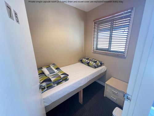 罗托鲁瓦Stay Hostel Rotorua的一间小卧室,配有床和窗户