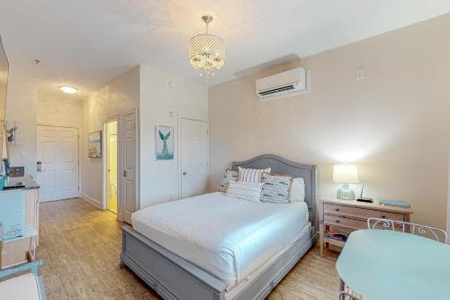 因莱特海滩Village of South Walton B247的一间卧室配有一张床和一个吊灯