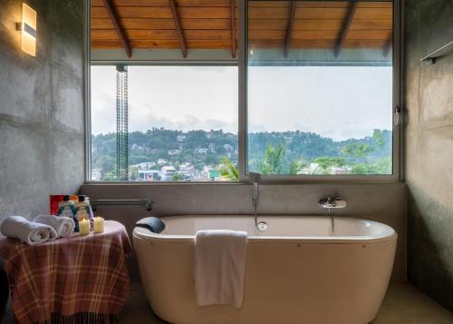 康提Kandy Tree Tops的带浴缸的浴室和大窗户