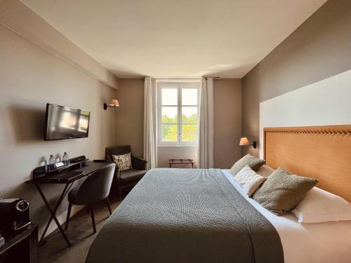 巴约讷贝司比利牛斯巴约讷酒店的一间卧室配有一张床、一张书桌和一个窗户。