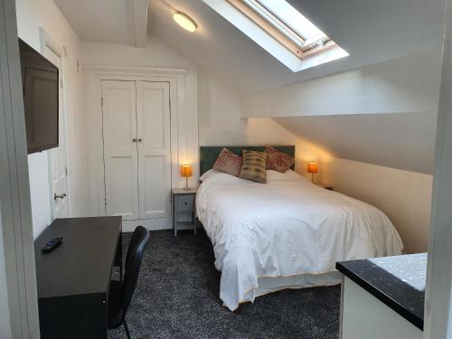 哈德斯菲尔德Lyndene House的一间卧室配有一张床、一张书桌和一个窗户。