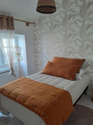 SoyauxMaison dépaysante au calme Soyaux Angoulême的一间卧室配有一张带棕色毯子的床