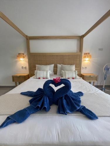 Moyo IslandBlue EmOcean resort的一张带有两条蓝色毛巾的心形床
