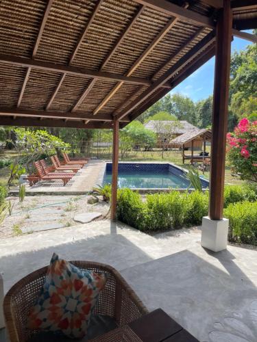 Moyo IslandBlue EmOcean resort的一个带桌椅的庭院和一个游泳池
