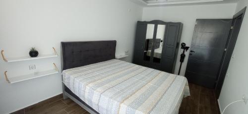 AğaçlıGray House Kusadasi的一间卧室设有一张床和一个黑色的门