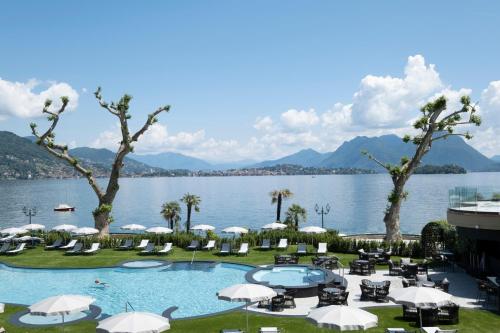 巴韦诺迪诺大酒店的湖畔带遮阳伞和椅子的游泳池