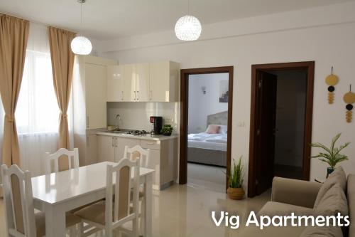 蒂米什瓦拉Vig Apartments的厨房以及带桌椅的起居室。