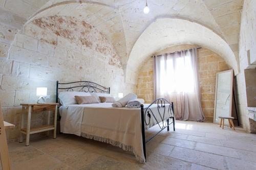 奥特朗托Antico Casolare P. P.的一间卧室设有一张床和石墙