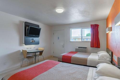 里弗顿里弗敦6号汽车旅馆的一间卧室配有一张床、一张书桌和一台电视。