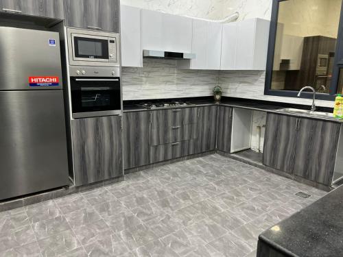 塞拉莱Sky ittin سما إتين的厨房配有不锈钢用具,铺有瓷砖地板。