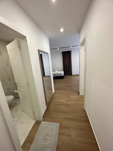 圣金Suite Hotel的走廊设有带卫生间和镜子的浴室