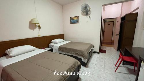 南奔塔恩通酒店的一间酒店客房,设有两张床和电视