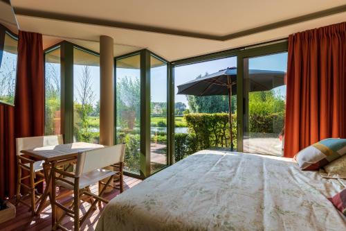 代因泽Villa Francine的一间卧室配有一张床、一张桌子和玻璃门