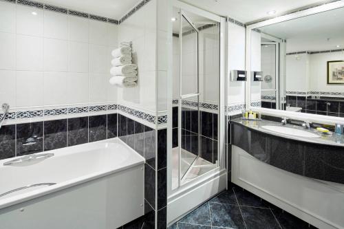 杜伦Delta Hotels by Marriott Durham Royal County的带浴缸、水槽和淋浴的浴室