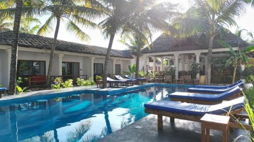 江比阿little pompeji boutique hotel - adults only的一个带躺椅和棕榈树的度假游泳池