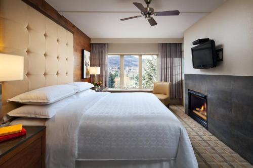 埃文Sheraton Lakeside Terrace Villas at Mountain Vista, Avon, Vail Valley的酒店客房配有一张床和一个壁炉。