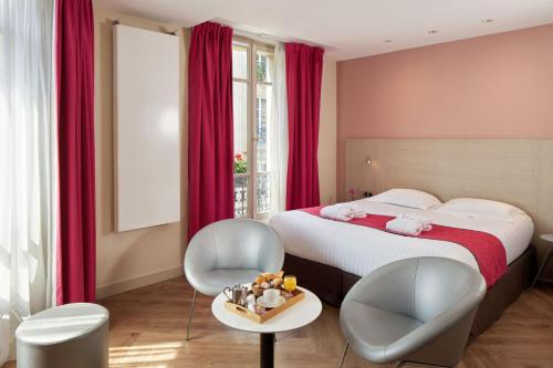 巴黎希维内酒店的一间卧室配有一张床、两把椅子和一张桌子