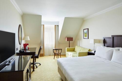比肯希尔Forest of Arden Hotel and Country Club的配有一张床和一张书桌的酒店客房