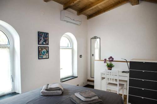 基亚瓦里La CASETTA Antica dimora nel centro storico的一间卧室配有一张床、一张书桌和两个窗户。