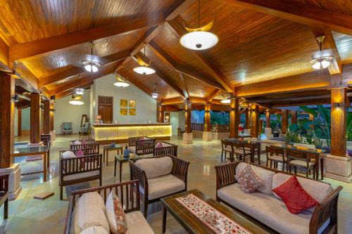 曼德姆里瓦海滩度假酒店的大堂设有木制天花板和桌椅。
