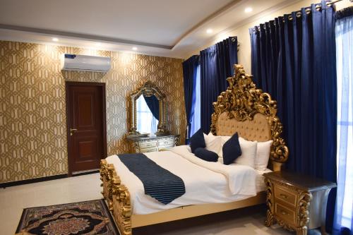 锡亚尔科特Hotel de Raj Sialkot的一间卧室配有一张特大号床和蓝色窗帘