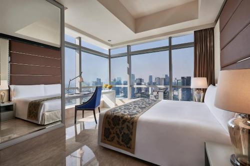 雅加达丽思卡尔顿酒店雅加达太古广场公寓的酒店客房设有一张床和一张书桌,享有美景。