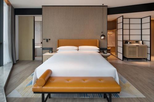 西安西安浐灞喜来登酒店的一张大床,在房间内配有长凳
