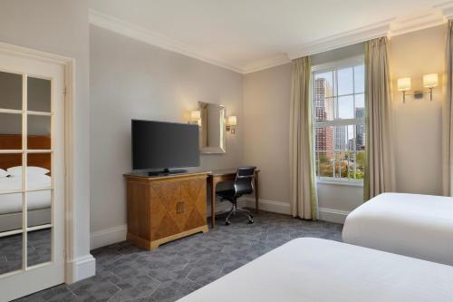 伯明翰Delta Hotels by Marriott Birmingham的酒店客房配有一张床和一张书桌及一台电视
