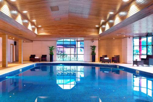 泰恩河畔纽卡斯尔Delta Hotels by Marriott Newcastle Gateshead的一座大型游泳池,位于一座拥有大型天花板的建筑内