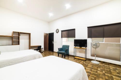 底拉斯卡拉OYO Hotel Boutique Las Campanas的酒店客房设有两张床和一台平面电视。