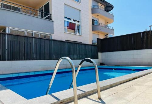 普拉Apartment Matea的一座带金属栏杆的游泳池,位于一座建筑旁边