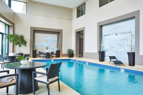 格伦维尤Renaissance Chicago Glenview Suites Hotel的一个带桌椅和桌子的游泳池以及一个游泳池