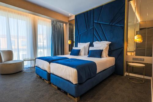 特尔戈维什泰HOTEL NOVA LUXURY的酒店客房设有一张大床和蓝色床头板
