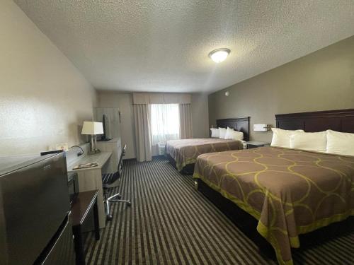 路易斯威尔DuPont Suites - Louisville - St. Matthews的酒店客房设有两张床和一台平面电视。