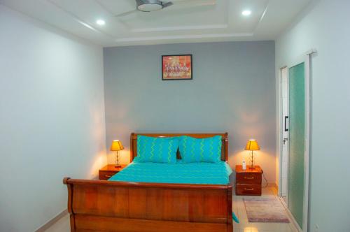 洛美Résidences 509的一间卧室配有一张带蓝色床单的床和两盏灯。