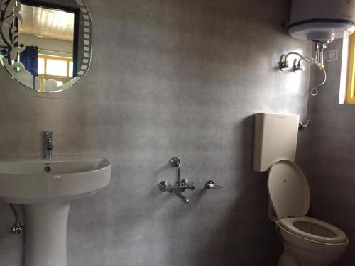 斯利那加Hotel city way的一间带水槽、卫生间和镜子的浴室