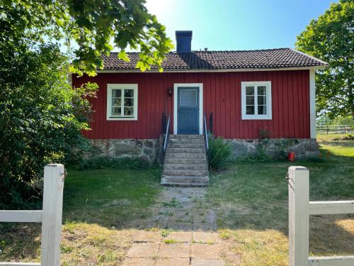 TingsrydCottage with beautiful nature, open landscape, forest and lakes I X I Stuga med fin natur, öppna landskap, skog och sjöar的红色的房子,有楼梯通往门