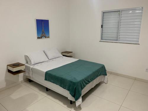 大伊瓜巴Loft PARIS para Casais, em Iguaba Grande, 150 metros da praia的一间卧室配有一张床,窗户带有塔楼