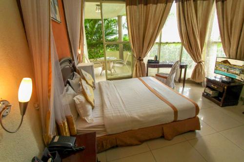 布琼布拉甜蜜生活度假酒店的一间带床的卧室,位于带窗户的房间内