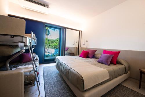 奥斯图尼玛赛丽亚圣塔卢西亚大酒店的一间卧室配有带粉红色枕头的床和窗户。