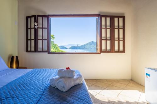 阿拉夏奇巴海滩Pousada Cruzoé的一间卧室配有一张蓝色的床和窗户