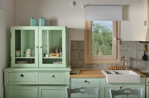 尼基季Villa Kladi的厨房配有白色橱柜、水槽和窗户。