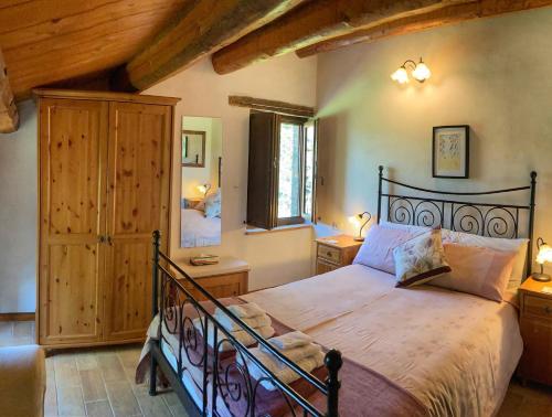 AmandolaIl Nascondiglio - The Hideaway的一间带一张大床的卧室,位于一个拥有木制天花板的房间