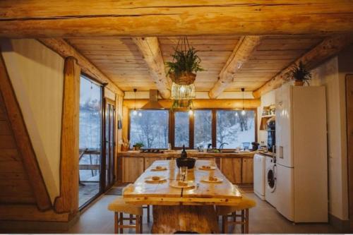 ŞurdeştiAframehouse的一间带桌子和冰箱的大厨房