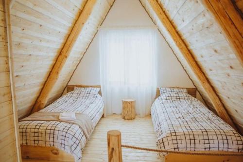 ŞurdeştiAframehouse的木房子阁楼上的两张床