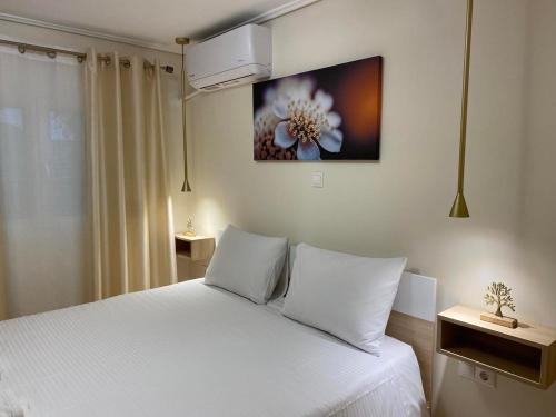 雅典Garden View Apartment的卧室配有白色的床和墙上的绘画作品
