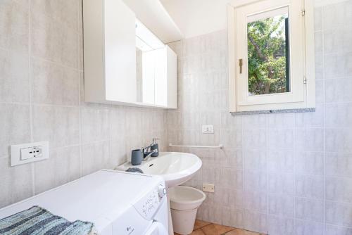 圣安德烈亚Villetta Sant'Andrea - Goelba的一间带水槽和卫生间的浴室以及窗户。